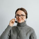 Friendly customer support woman smiling while wearing a headset in the office.